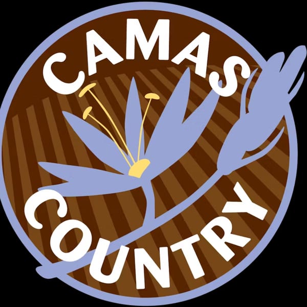 Camas Country logo, a brown circle with a light blue flower and "Camas Country" text.